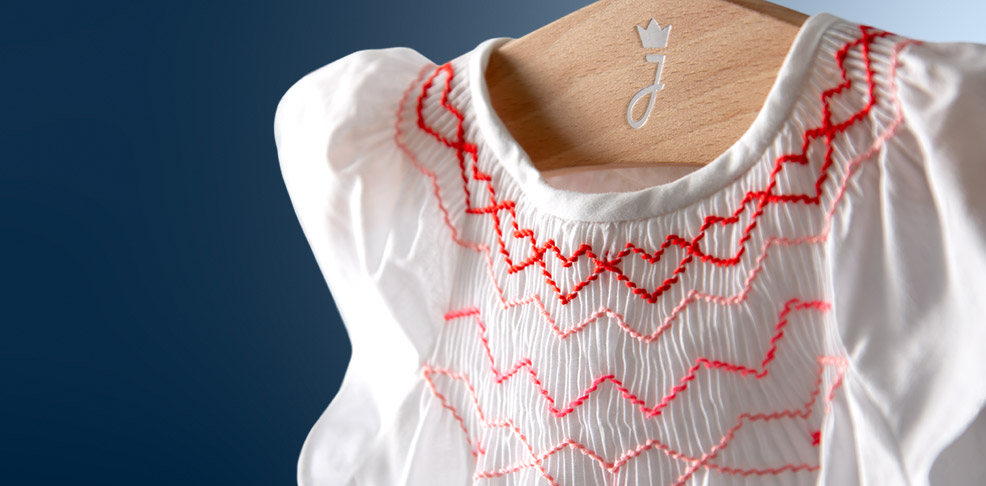 L'iconico abito a punto smock per neonatae